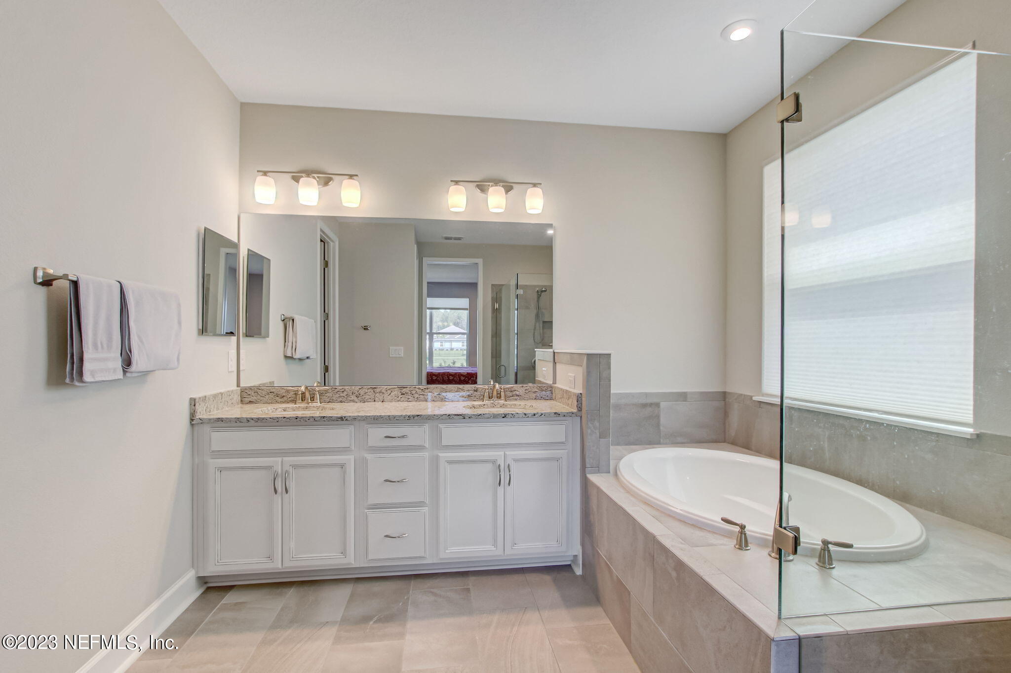 85276 Berryessa Way Yulee, FL 32097 - Photo 23 of 42 a spacious bathroom with a granite countertop tub sink and mirror