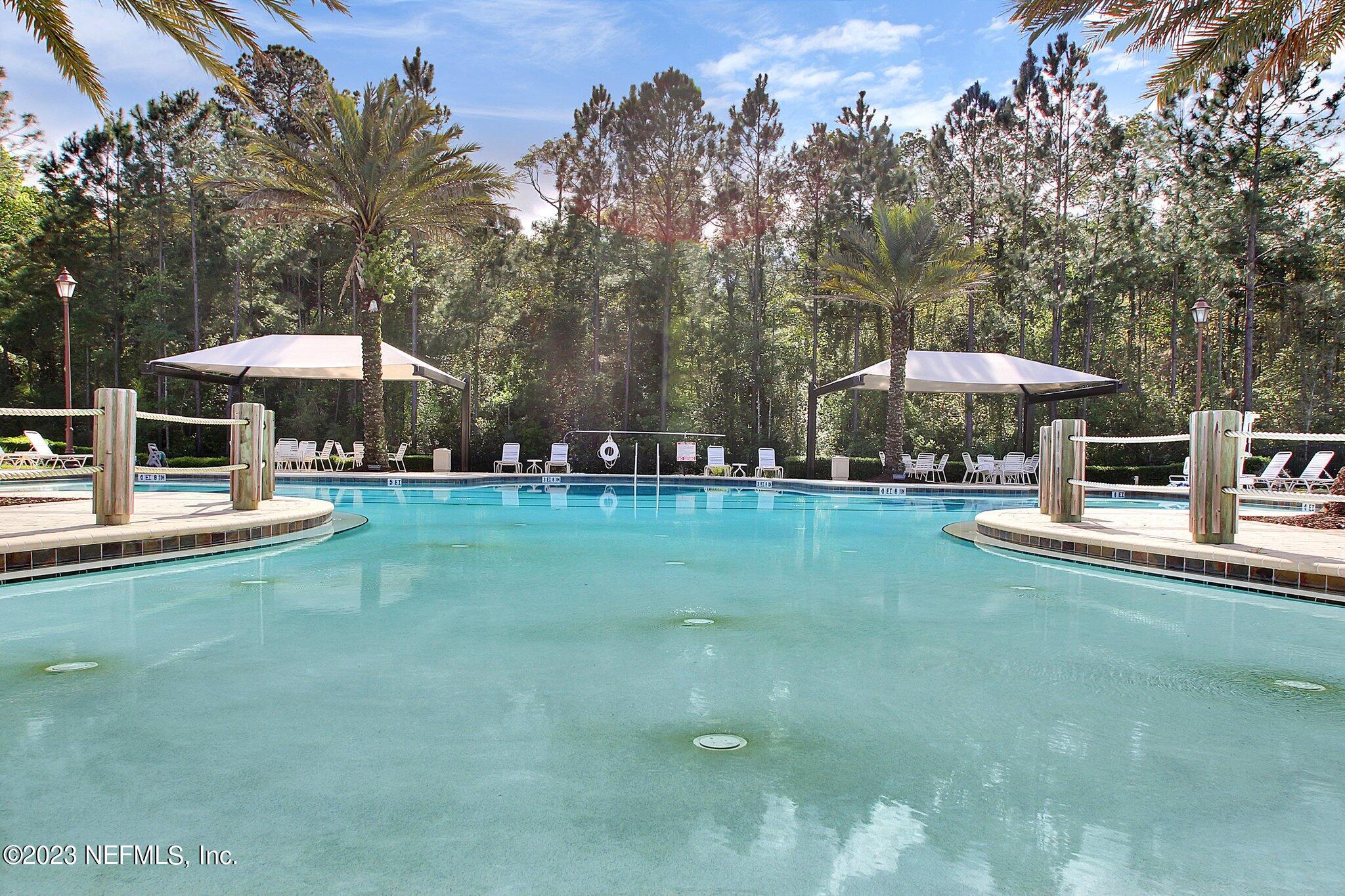 85276 Berryessa Way Yulee, FL 32097 - Photo 39 of 42 a view of a swimming pool with lawn chairs under an umbrella