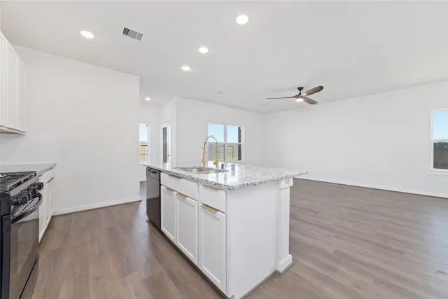 a kitchen with granite countertop a stove and a sink