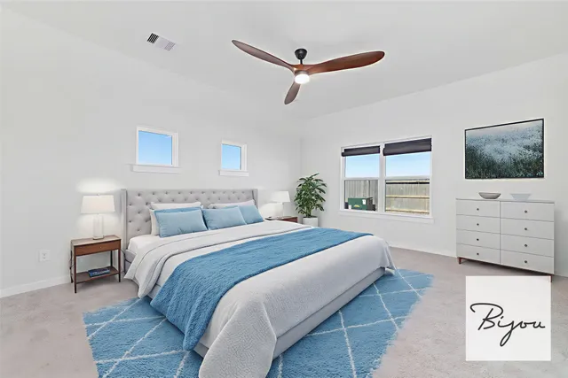 a bedroom with a bed a window and a flat screen tv