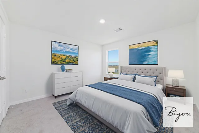 a bedroom with a bed and painting on the wall