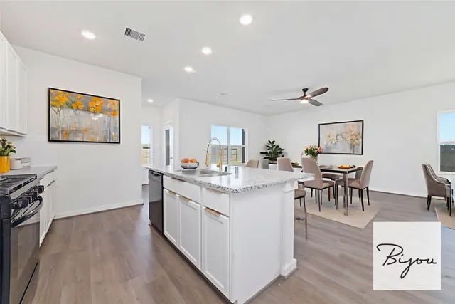 a kitchen with stainless steel appliances granite countertop a living room and couches with wooden floor