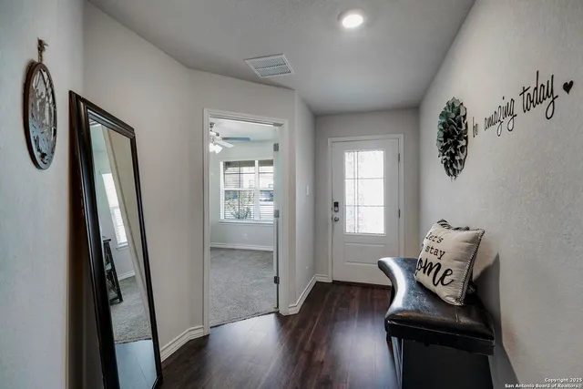 a view of a hallway with wooden floor and glass door