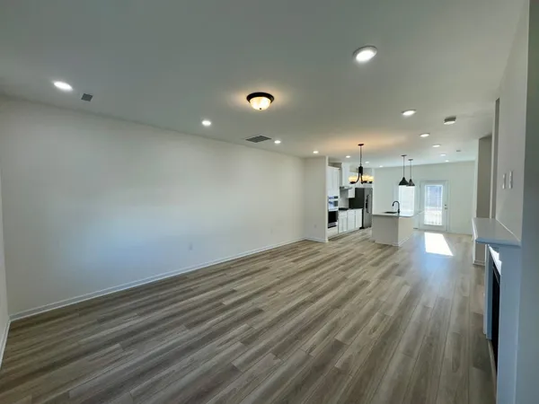 a view of a room with wooden floor and a window
