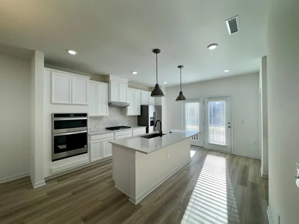 a kitchen with kitchen island a stove and a wooden floors