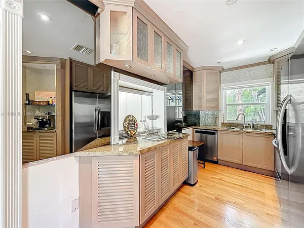 a kitchen with stainless steel appliances granite countertop a sink refrigerator and cabinets