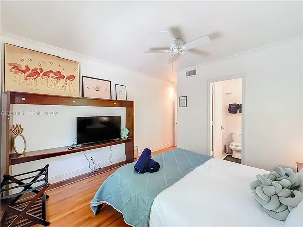 a bedroom with a bed and wooden floor