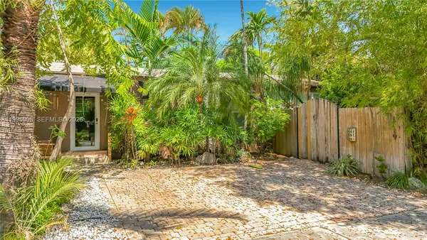 a view of a house with backyard and trees