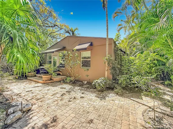 a view of backyard with swimming pool and seating space