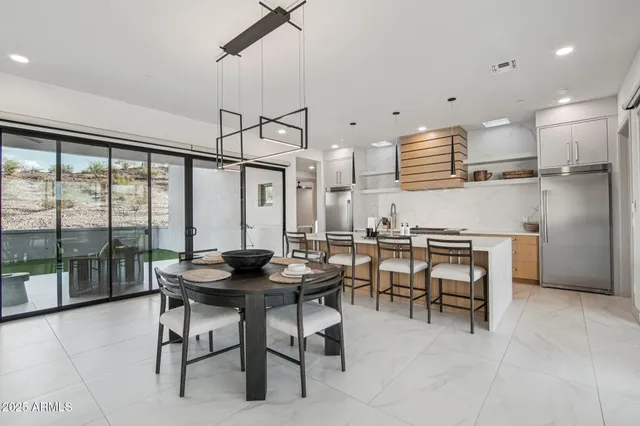 a kitchen with a table chairs refrigerator and cabinets