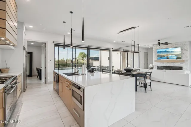 a spacious bedroom with a bed a dresser and a chandelier