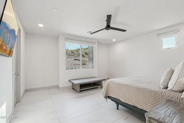 a spacious bedroom with a bed and a ceiling fan