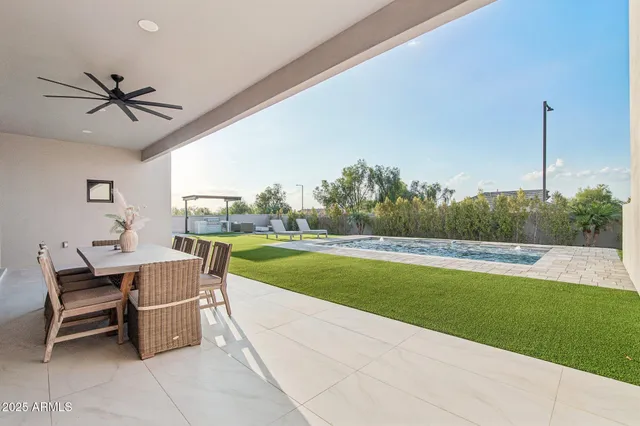 a living room with a table chairs and a floor to ceiling window