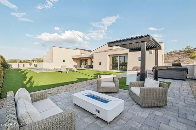 a view of a patio with couches table and chairs with swimming pool and barbeque oven