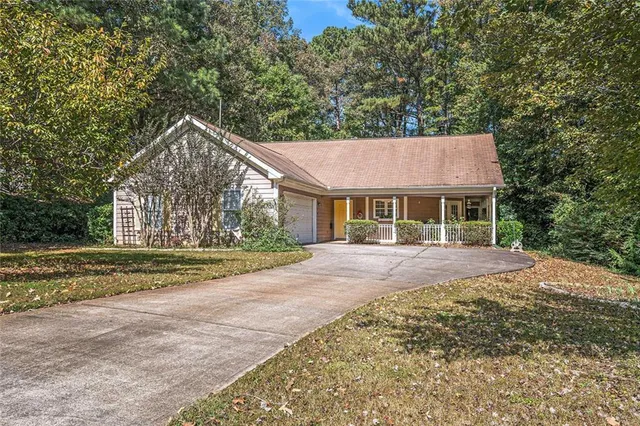 a view of a house with a yard and large tree