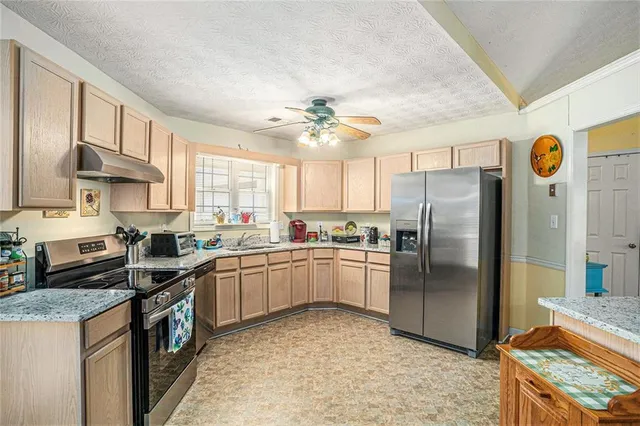 a kitchen with stainless steel appliances granite countertop a stove refrigerator sink and dishwasher