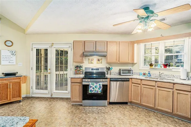 a kitchen with stainless steel appliances granite countertop a stove sink and cabinets