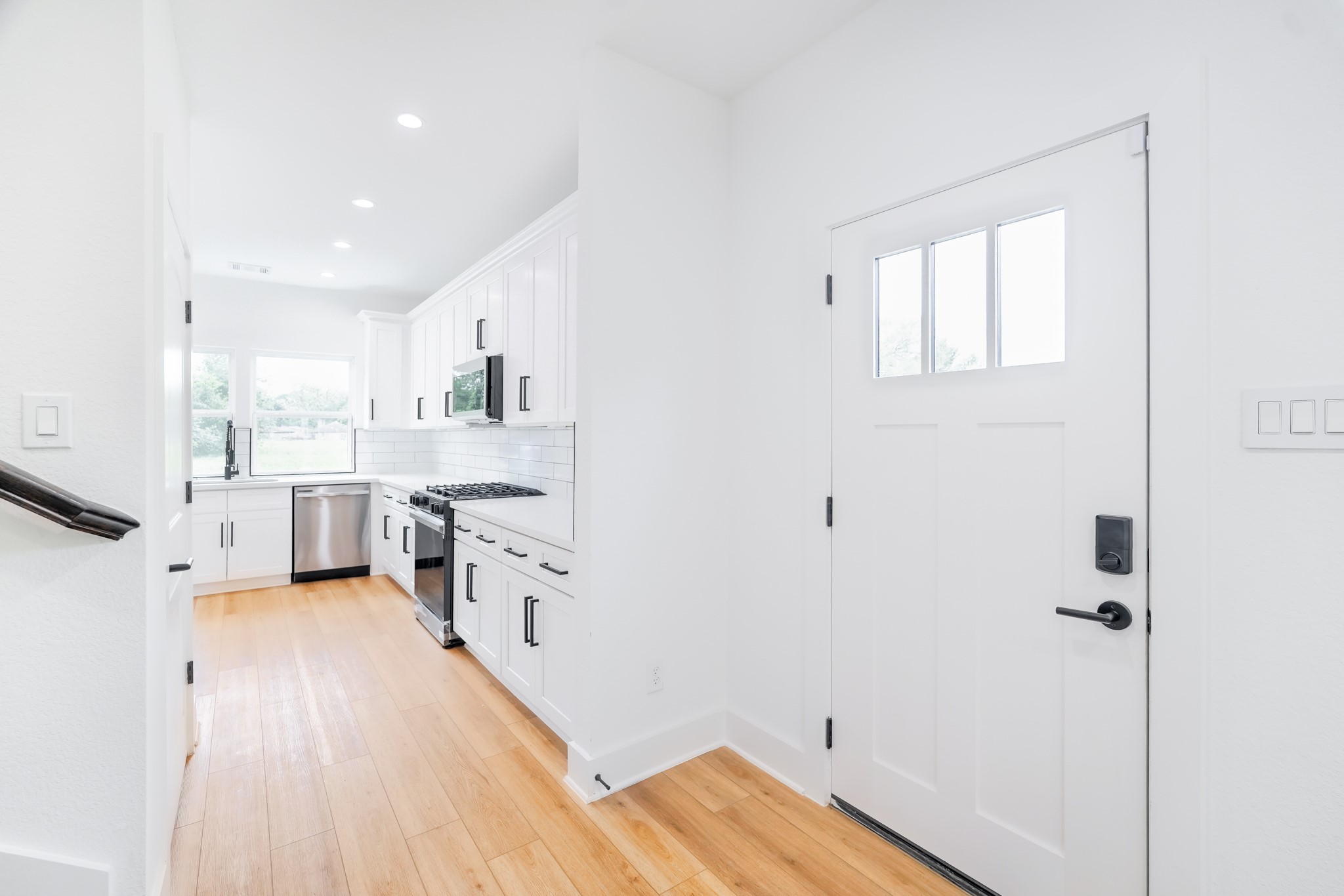 7903 Sunnyhill Street Houston, TX 77088 - Photo 4 of 33 a view of a kitchen with a white cabinets stove and wooden floor