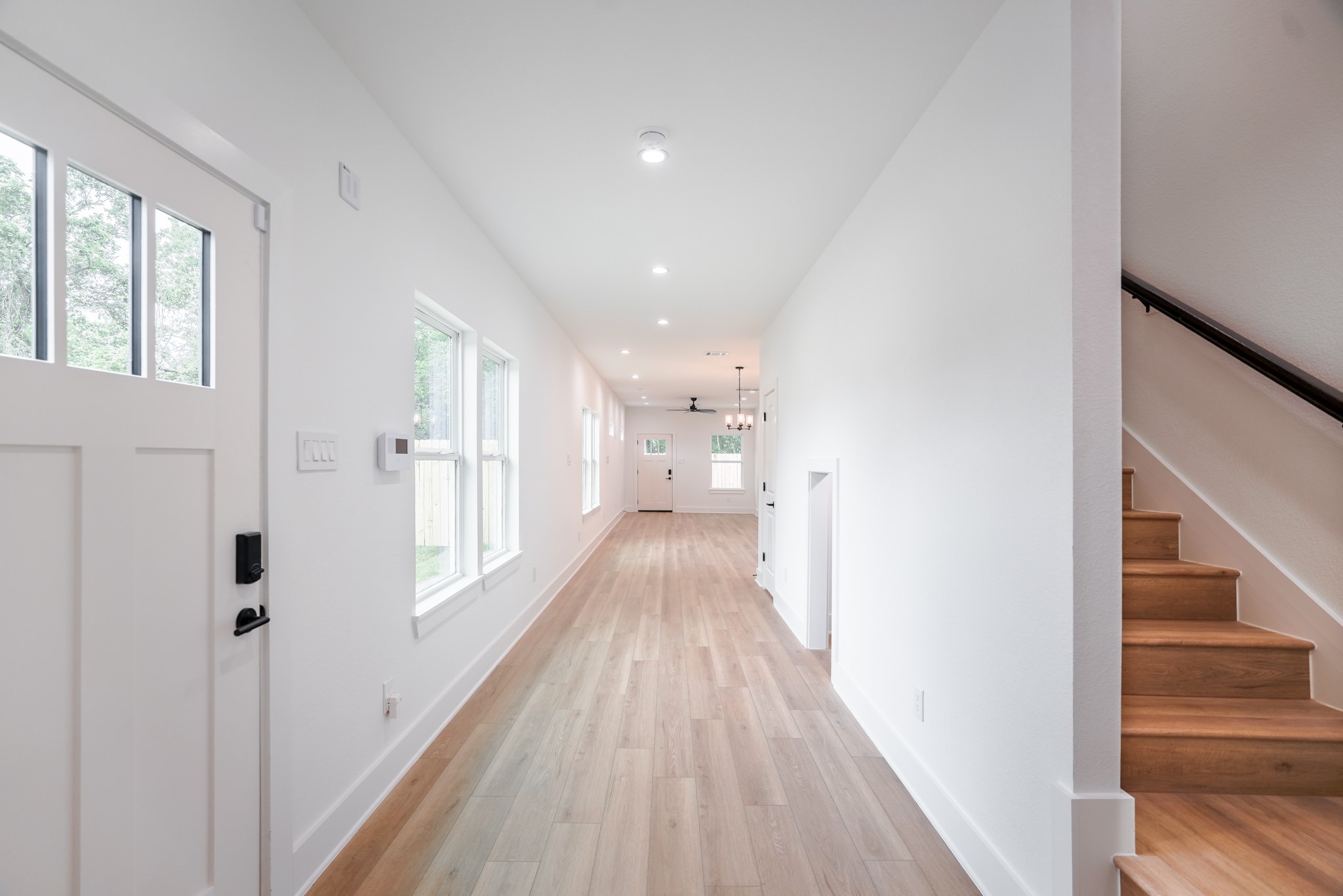 7903 Sunnyhill Street Houston, TX 77088 - Photo 10 of 33 a view of a hallway with wooden floor and staircase