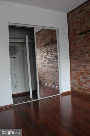 an empty room with wooden floor and closet