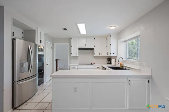 a kitchen with stainless steel appliances a refrigerator sink and microwave
