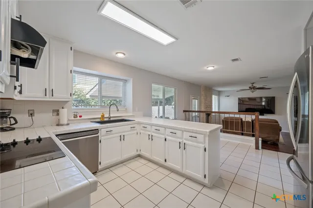 a kitchen with white cabinets and appliances