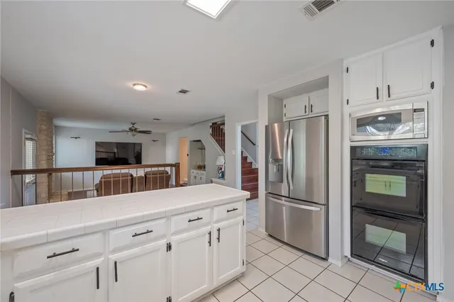 a kitchen with white cabinets and stainless steel appliances