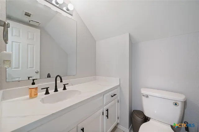 a bathroom with a sink toilet vanity and tub