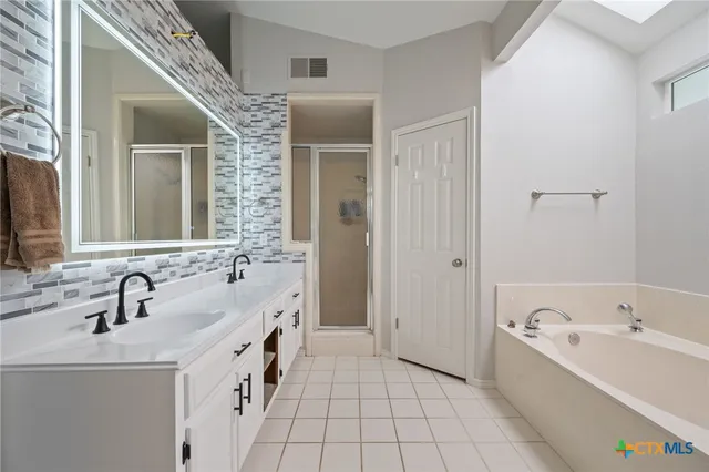 a bathroom with a tub sink and mirror