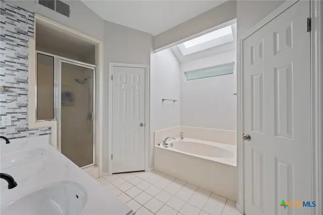 a spacious bathroom with a tub shower and sink