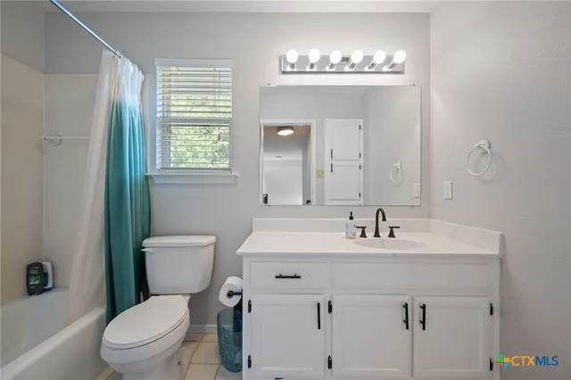 an empty room with a window and a ceiling fan