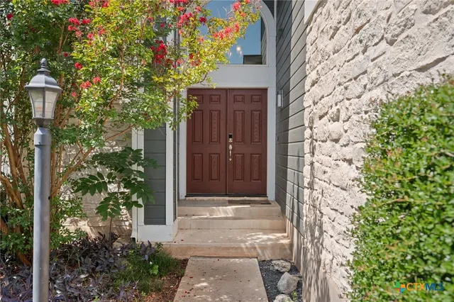 a front view of a house with a tree