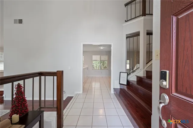 a view of a hallway with wooden floor and staircase