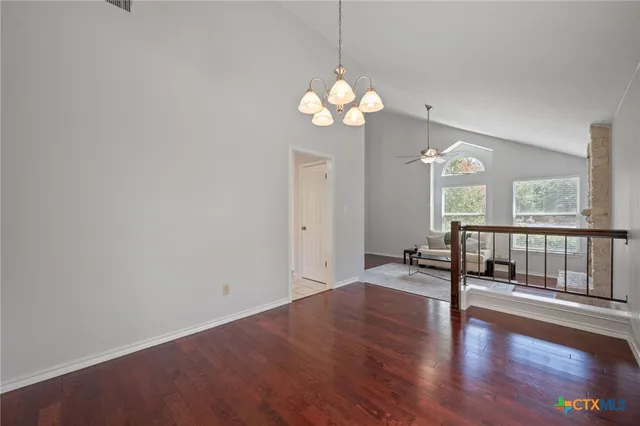 a view of an empty room with wooden floor and a large window