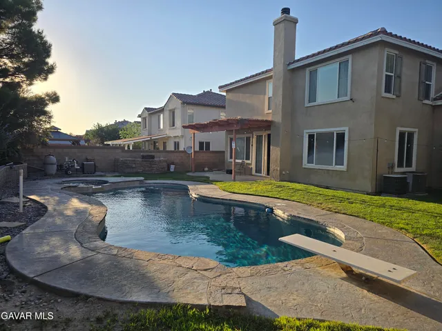 a view of a house with swimming pool and a yard