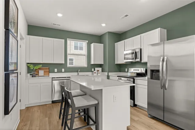 a kitchen with white cabinets and stainless steel appliances