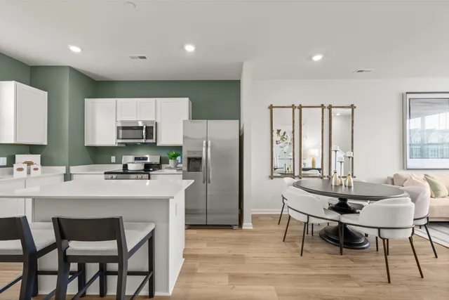 a kitchen with stainless steel appliances a dining table chairs microwave and sink