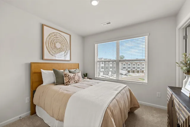 a bedroom with a bed and dresser with mirror