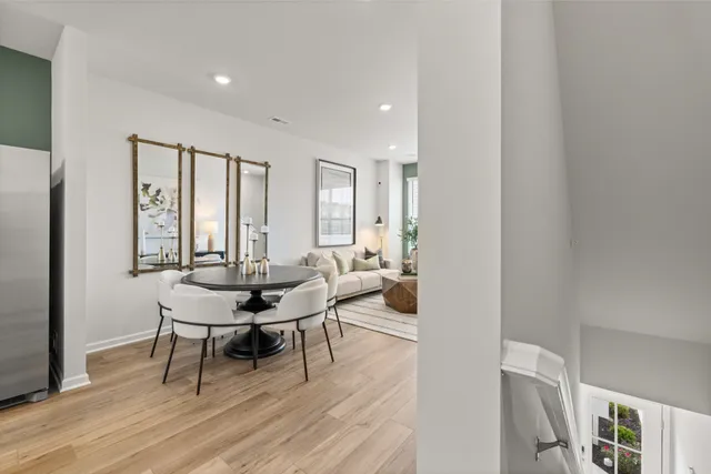 a living room with furniture a large window and wooden floor