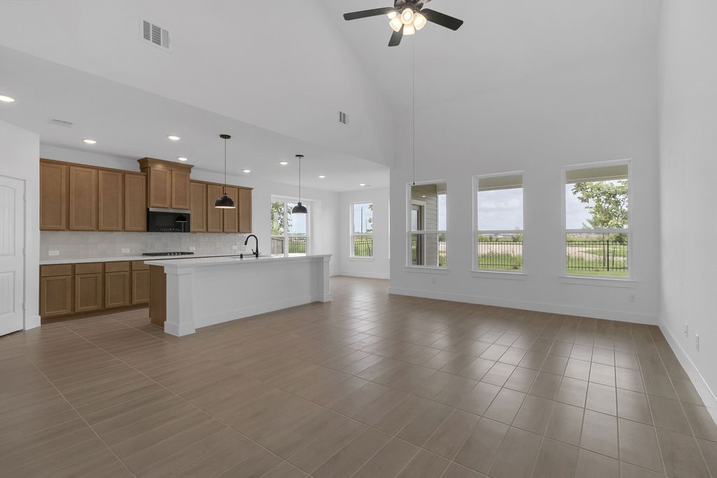 a large kitchen with a large counter top stainless steel appliances and cabinets