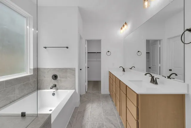 a bathroom with a tub sink and mirror