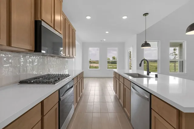 a kitchen with stainless steel appliances granite countertop a sink stove and cabinets