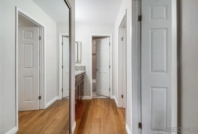 a view of a hallway with wooden floor and staircase