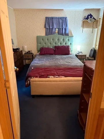 a bed sitting in a bedroom next to a window