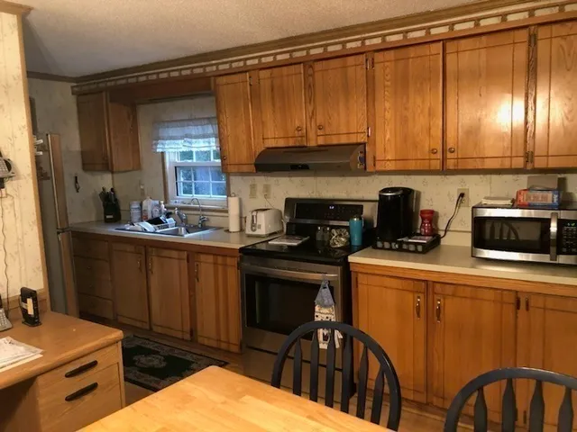 a kitchen with stainless steel appliances a stove a sink and cabinets