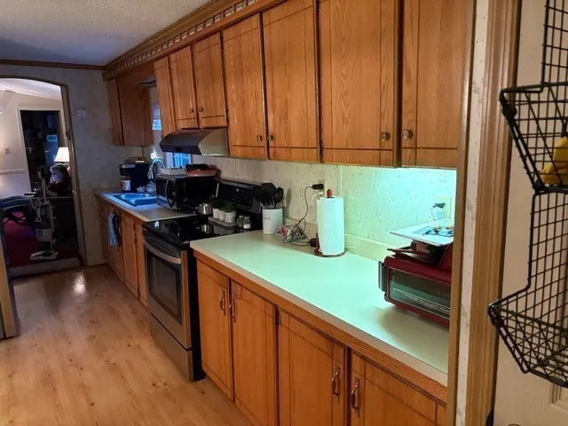 a kitchen with green cabinets a stove and a window