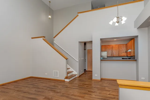 a view of a livingroom with wooden floor and staircase