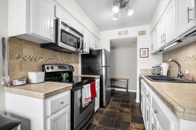 a kitchen with stainless steel appliances granite countertop a sink stove and refrigerator
