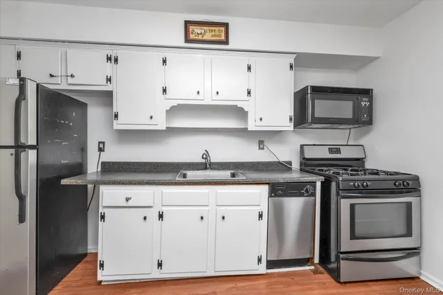 a kitchen with granite countertop white cabinets and stainless steel appliances