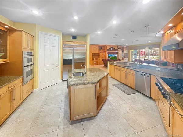 a kitchen with stainless steel appliances granite countertop a sink and cabinets